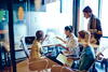 a group of people in a conference room working together looking at a chart